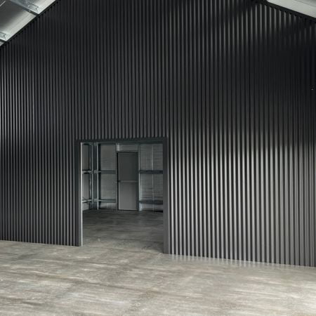 Cladded interior wall to separate two-bay garage and man cave.