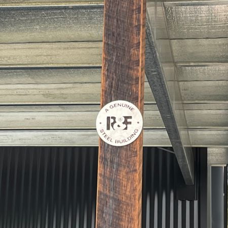Close up of hardwood awning posts with R&F stainless style shed badge.