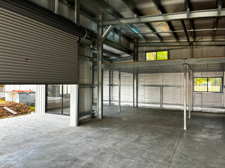 Custom shed interior with mezzanine, windows and glass sliding door in a unique building layout