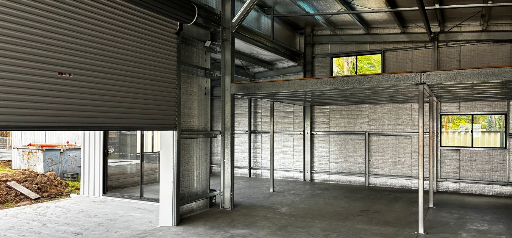 Custom steel garage build in Brisbane with mezzanine floor and natural light from windows